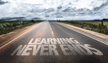 Road with a sentence written on it: "Learning Never Ends"